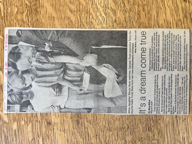Newspaper clipping showing a mortgage document being burned by a Canada Trust executive, as a surprised-looking woman watches.